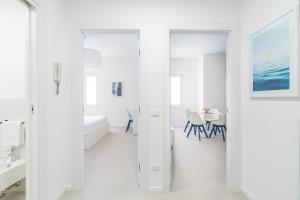 a white bathroom with a sink and a mirror at Puolo Seaside Apartment 3 in Massa Lubrense +4 photos