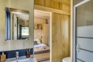 une salle de bains avec un lavabo et un miroir dans l'établissement Slow Village Saint-Cybranet - Périgord, à Saint-Cybranet 52 autres photos