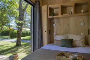 a bedroom with a bed and a large window at Slow Village Saint-Cybranet - Périgord in Saint-Cybranet