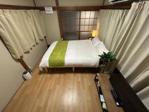 una piccola camera da letto con un letto e una finestra di Villa FUNABASHI a Funabashi