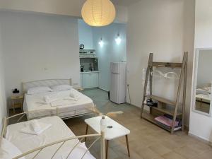 ein Zimmer mit zwei Betten und einer Küche in der Unterkunft Deos Thassos in Panagia