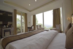 Postel nebo postele na pokoji v ubytování The Four Season Dharamshala # Centrally Heated & Air Cooled # Scenic Mountain View # Big Parking # Near Market # Top Rated # Most Awarded # Premium Rooms # Bar # Terrace # Lift # Property Of The Year##BY ROYAL CASTLE DHARAMSHALA#