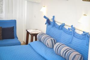 a blue couch with pillows on it in a room at Hotel Villa Denia in San Vincenzo