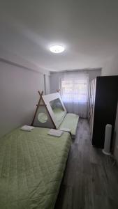 Un dormitorio con una cama con un edredón verde. en Lorent Apartment, en Prizren