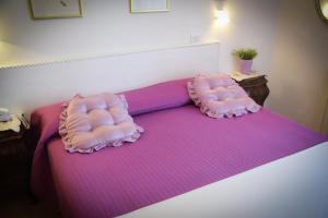 a bed with two pillows on top of it at Hotel Villa Denia in San Vincenzo