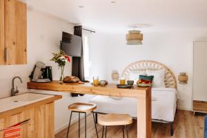 a kitchen with a table and a bed in a room at Slow Village Séveilles - Périgord in Valades