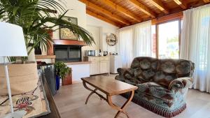 a living room with a leather couch and a table at Acero Rosso in Fontane