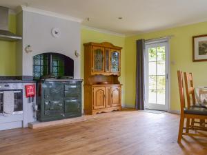 a kitchen with green walls and a wooden floor at Loch Long View in Sallachy +14 photos