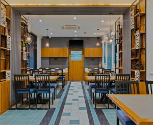 a dining room with wooden tables and chairs at Hotel The Container Kolhapur in Kolhapur