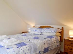 a bedroom with a bed with towels on it at Kirsty Cottage in Moffat