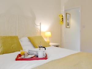 a bed with a tray of food and drinks on it at Jasmine Cottage in Keswick +6 photos