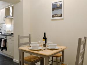a kitchen with a table with a bottle of wine at Jasmine Cottage in Keswick