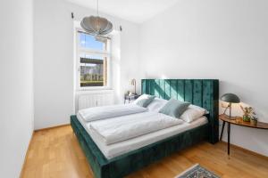 a bedroom with a large bed with a green headboard at Stylische Altbauwohnung Bregenz am See in Bregenz
