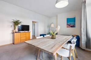 a living room with a wooden table and chairs at Stylische Altbauwohnung Bregenz am See in Bregenz