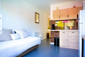 a bedroom with a bed and a kitchen with a sink at Studio 2-3 personnes piscine partagée in Château-dʼOlonne