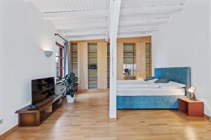 a bedroom with a large bed and a tv at Villa Seeblick 1908 in Bregenz