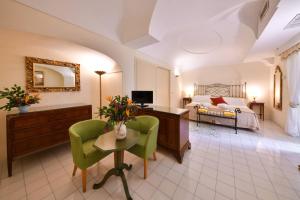 a hotel room with a bed and a desk and chairs at Grand Hotel Terme di Augusto in Ischia