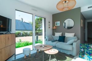 a living room with a blue couch and a table at Maison HG - Presqu'ile de Crozon in Plomodiern