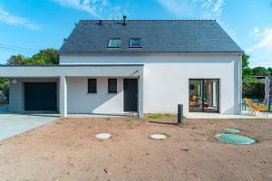 a white house with a dirt yard in front of it at Maison HG - Presqu'ile de Crozon in Plomodiern