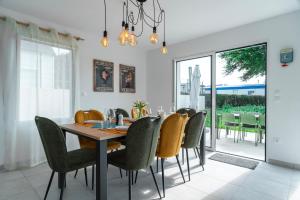 a dining room with a wooden table and chairs at Maison HG - Presqu'ile de Crozon in Plomodiern