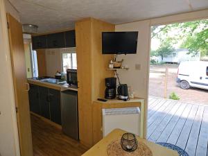 a kitchen with a table and a tv on the wall at Le calme in Braize