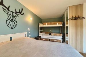 una camera da letto con un letto con una testa di cervo sul muro di Cosy 30m in the heart of Combloux a Combloux