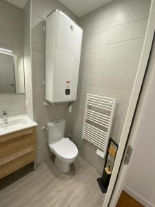 een badkamer met een wit toilet en een wastafel bij Logement Neuf Cosy avec Espaces Communs Premium 13 in Belfort +22 foto's