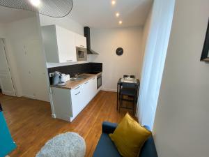 een keuken met een bank en een tafel in een kamer bij Logement Neuf Cosy avec Espaces Communs Premium 13 in Belfort
