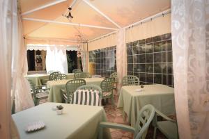 a room with tables and chairs with green table cloth at Hotel Villa Denia in San Vincenzo