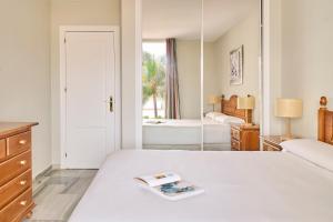 a bedroom with a large white bed and a mirror at Ona Campanario in La Cala de Mijas