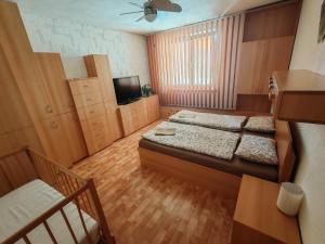a small room with two beds and a television at Apartmán Iris in Václavov