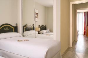 a bedroom with a white bed and a mirror at Ona Campanario in La Cala de Mijas