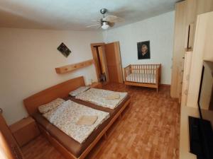 a small bedroom with two beds and a crib at Apartmán Iris in Václavov
