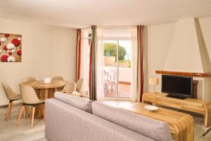 a living room with a couch and a tv and a table at Ona Campanario in La Cala de Mijas