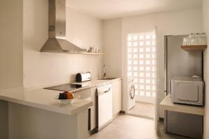 a white kitchen with a sink and a microwave at Ona Campanario in La Cala de Mijas