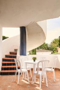 a white table and chairs on a patio with stairs at Ona Campanario in La Cala de Mijas