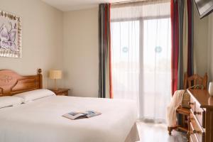 a bedroom with a bed and a window with a book on it at Ona Campanario in La Cala de Mijas