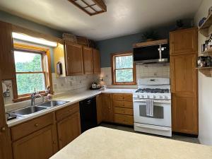 a kitchen with a white stove and a sink at The Sweet Maple Getaway & Maple Welcome Gift! in Rochester