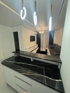 a kitchen with a counter top and a living room at White Home in K'obulet'i +1 photo