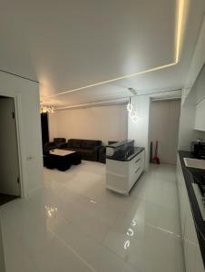 a kitchen and a living room with a couch at White Home in K'obulet'i