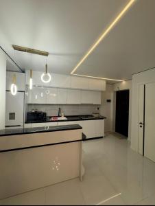 a kitchen with white cabinets and a counter top at White Home in K'obulet'i
