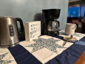 a table topped with a blue and white table cloth with a coffee pot at The Sweet Maple Getaway & Maple Welcome Gift! in Rochester