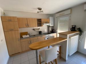 シルティカイムにあるLa Résidence St Arnould, À 10 min du centre de Strasbourgのキッチン(木製キャビネット、木製テーブル付)