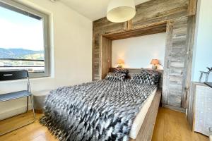 Un dormitorio con una cama grande con una pared de madera. en Le Repère de l'Ours, en Megève