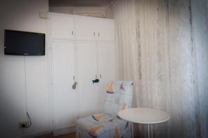 a room with a table and a chair and a tv at Hotel Villa Denia in San Vincenzo