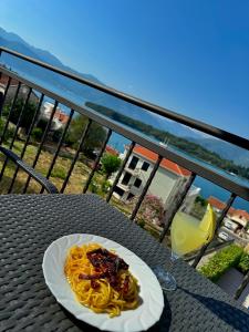 un plato de pasta en una mesa en un balcón en Annabell apartman, en Tivat