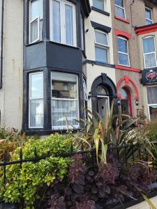 a house with a bunch of plants in front of it at Edenfield Lodge in Blackpool