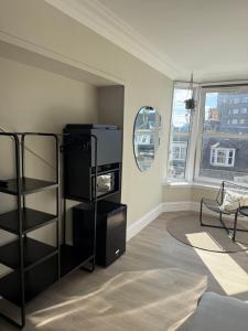a living room with a black book shelf at Park House Rooms - Sky TV and kitchenette in Aberdeen