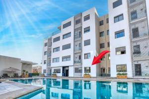 a building with a swimming pool in front of a building at Sergio by atlas in Agadir