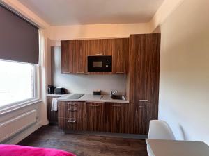 a small kitchen with a sink and a microwave at London Studio Retreat - Colney Hatch Lane in London +11 photos
